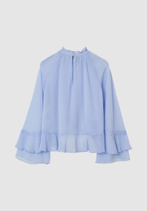 Blouse bleu clair fluide avec un col montant, un col à volants et des manches évasées. Présente une texture subtile et un détail de bas à couches.
