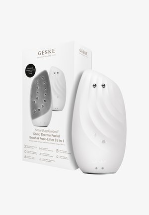 Witte gebogen sonische thermo gezichtsborstel en face-lifter apparaat met twee metalen bollen, weergegeven naast de verpakking.