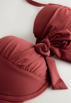 Bordowy pikowany top bikini z węzłowym paskiem. Gładka tkanina, profilowany kształt i szczegółowe przeszycia wzdłuż krawędzi.