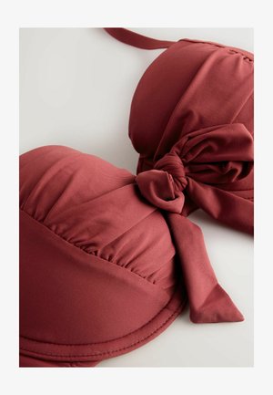 Bordó színű párnázott bikini felsőrész csomós pánttal. Sima anyag, formázott szabás és részletes varrás az éleknél.