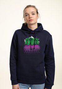 Felpa blu marina con un grafico che presenta personaggi verdi pixelati su uno sfondo a griglia viola. Include cordini e tasca frontale.