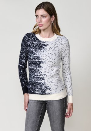 Pull en tricot présentant un design dégradé noir et blanc avec une texture mouchetée. Encolure et poignets côtelés, avec une silhouette ajustée.
