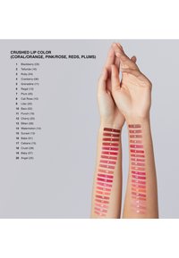 Próbki 20 rozdrobnionych kolorów pomadek wyświetlone na dwóch ramionach. Każdy kolor ma przypisany numer i odpowiada różnym odcieniom różu, czerwieni i śliwki.