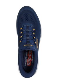 Zapatilla deportiva azul marino con upper de malla transpirable, patrón texturizado, detalles amarillos y diseño sin cordones. Cuenta con una plantilla acolchada.