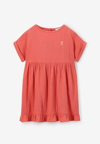 Robe en coton couleur pêche avec des manches courtes, un col rond, une taille froncée et un ourlet à volants ; présente un petit détail de broderie en forme de cœur.