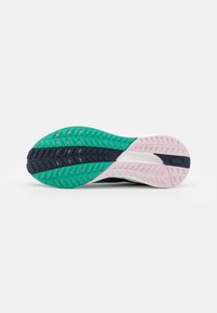 Sole of a sneaker showing multicolor tread in green, navy, and pink, with textured grip patterns on a white background.