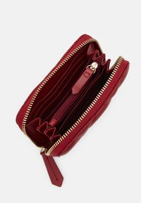 Κόκκινο ψεύτικο δερμάτινο πορτοφόλι με χρυσό φερμουάρ, αρκετές θήκες καρτών και μια θήκη με φερμουάρ για κέρματα. Διαθέτει υφή με διαμαντένιο σχέδιο.