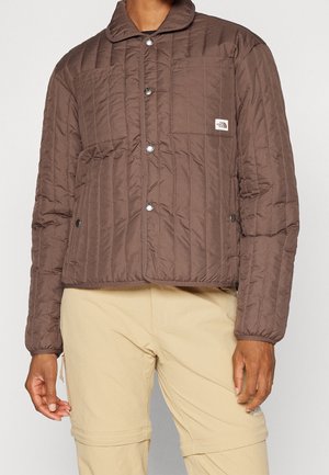 Brown quilted jacket with snap buttons and chest pocket, paired with beige convertible cargo pants.