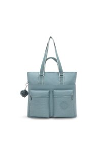 Hellblaues Tote-Bag mit zwei vorderen Reißverschlusstaschen, einem strukturierten Material, Schulterriemen und einem flauschigen Pompon-Accessoire. Mit Logo-Patch.