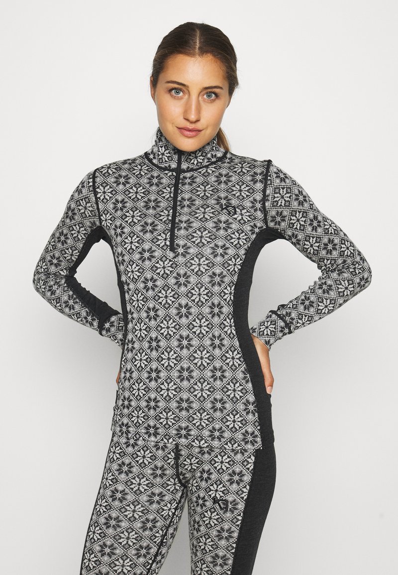 Čierny a šedý zip-up top s geometrickým vzorom, dlhými rukávmi a vysokým golierom. Vyrobené z elastickej, textúrovanej tkaniny pre pohodlie.