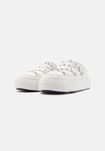 Λευκά sneakers χαμηλού ύψους από λείο ύφασμα με υφή, με παχιά σόλα, κορδόνια σε αντίθετο χρώμα και διακριτικές ραφές.