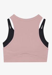 Lichtroze sportbeha met een ribbeltextuur en zwarte bandjes. Heeft een ronde halslijn en een naadloze achterkant voor comfort.