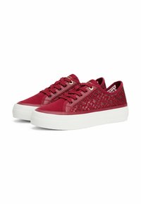Zapatillas de lona rojas con paneles laterales estampados, suelas de goma blanca y cordones frontales con ojales dorados. Superficies planas y texturizadas.