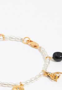 Bracciale in oro e perle con perle ovali, una perlina nera e dettagli con charm; include una chiusura a moschettone.