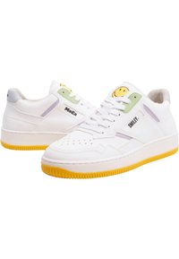 White sneakers with a textured leather upper, yellow rubber sole, and pastel green and purple accents. Features a smiley logo on the tongue.