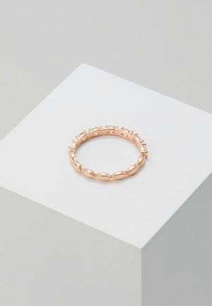 Anello in oro rosa con design attorcigliato, caratterizzato da bordi lisci e arrotondati e piccoli accessori decorativi lungo il bordo superiore.