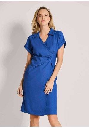 Blauwe wikkeljurk met een V-hals, korte mouwen en een ruchingdetail op de taille. Gemaakt van een gestructureerde stof met een knielange snit.