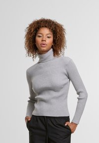 Szary sweter z rabatami i golfem, z długimi rękawami, dopasowany krój, teksturowana dzianina oraz wysoki kołnierz, włożony do czarnych spodni.