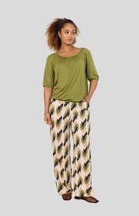 Green, short-sleeve top with a rounded neckline paired with wide-leg pants featuring a multicolored, abstract pattern.