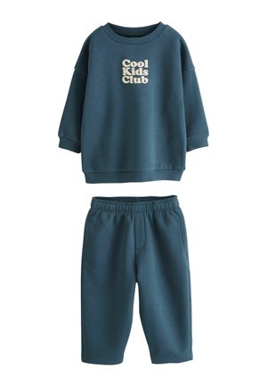 Dunkel türkisfarbenes Kinder-Sweatshirt und passender Hose, das Sweatshirt hat vorne den Text "Cool Kids Club" in heller Farbe.