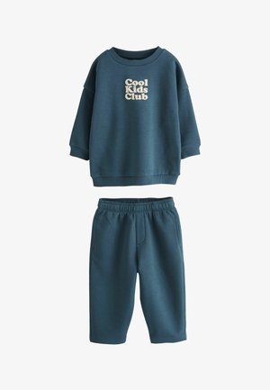 Zestaw ciemnoturkusowa dziecięca bluza i pasujące spodnie, bluza ma na przodzie tekst "Cool Kids Club" w jasnym kolorze.