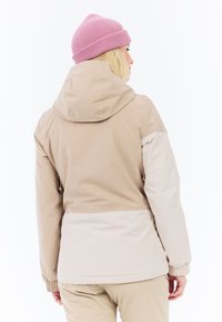 Beige Kapuzenjacke mit elastischen Bündchen und Farbblock-Design. Weiches Material, glatte Textur und ein hellbeiges Unterteil.