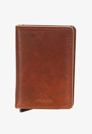 Braunes Lederportemonnaie mit sichtbaren Nähten und dem Schriftzug "SECRID" in der Nähe des Bodens, mit einem teilweise rechts sichtbaren Metallkartenhalter.