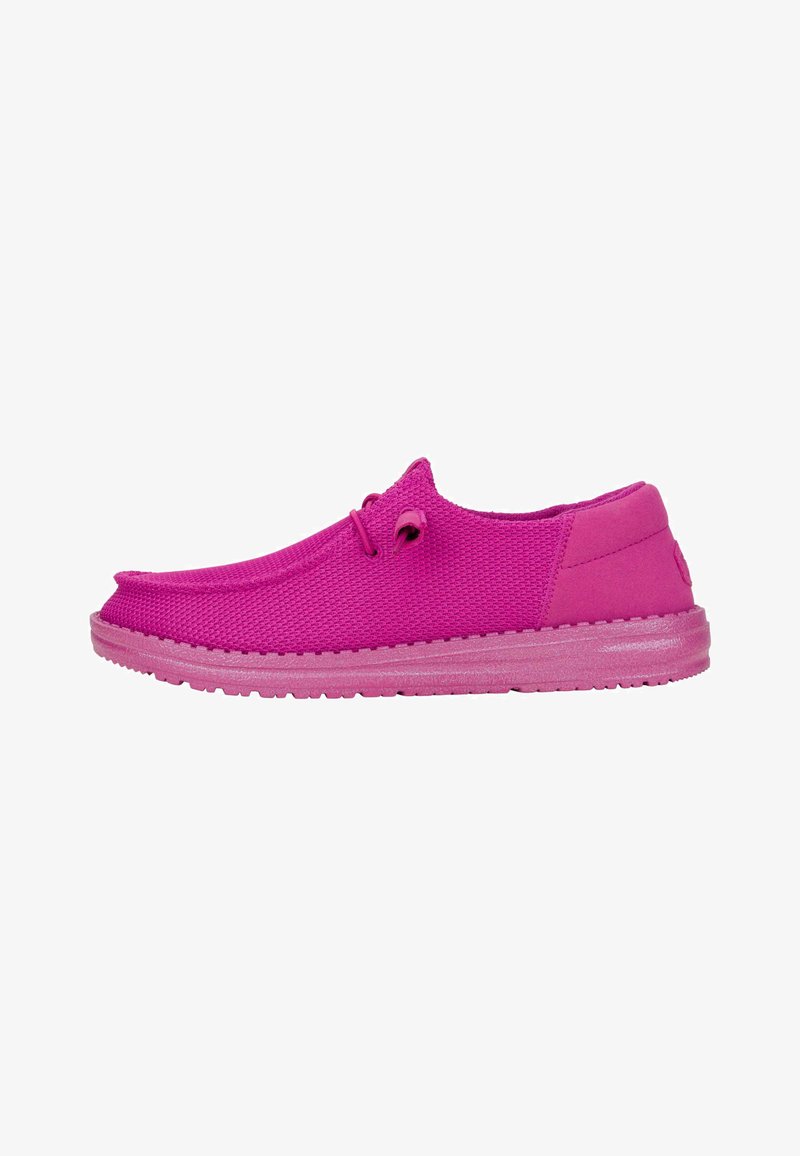 Zapatos de lona de color rosa brillante con una parte superior de tejido texturizado, punta redondeada y suela de goma flexible. Detalle sutil de encaje en el lateral.