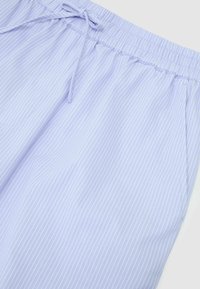 Pantalon bleu clair à fines rayures blanches verticales, taille élastique avec cordon de serrage, présenté à plat sur fond blanc.
