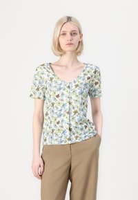 Top floreale a maniche corte con scollo a V, caratterizzato da uno sfondo azzurro chiaro e fiori ricamati in verde, marrone e blu. Tessuto morbido.