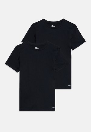 Deux t-shirts noirs unis Nike à manches courtes avec col rond, empilés, chacun présentant un petit logo blanc Nike près de l'ourlet inférieur.