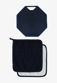 Ciemnoniebieska ośmiokątna silikonowa mata z wypukłymi kropkami na powierzchni; poniżej dwa ręczniki: jeden z ciemnoniebieskiej frotté, drugi biały z granatowym wykończeniem.