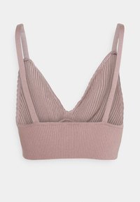 V-ringad bralette i dammig rosaribbat tyg, med justerbara axelband och en scalloped kant längs halsringningen och under bysten.