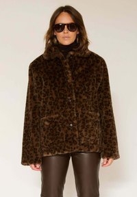 Veste en fausse fourrure imprimé léopard marron avec col, fermeture à boutons et deux poches avant. Texture lisse et coupe ample.