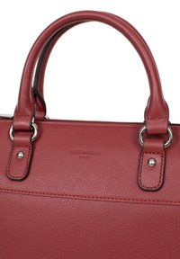Rode leren handtas met textuurafwerking, dubbele handvatten, zilveren hardware en reliëfmerklogo. Voorzien van een ritssluiting en gedetailleerde stiksels.