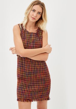 Vestido de tweed multicolorido con un patrón texturizado y tejido. Diseño sin mangas, escote redondo y con borde de flecos en el dobladillo.