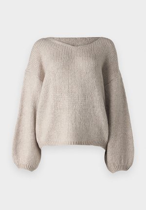Pull en tricot beige avec un large col en V, des manches longues bouffantes et un ourlet court. La texture est épaisse et douce, avec un design simple.