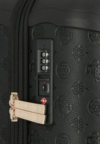 Maleta negra texturizada con patrones en relieve, doble cierre dorado y una cerradura de combinación aprobada por la TSA.