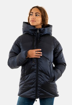 Veste matelassée marine avec un col haut, un quilt en chevrons, une fermeture éclair frontale et des cordons de serrage. Dotée de poches latérales et d'une finition brillante.