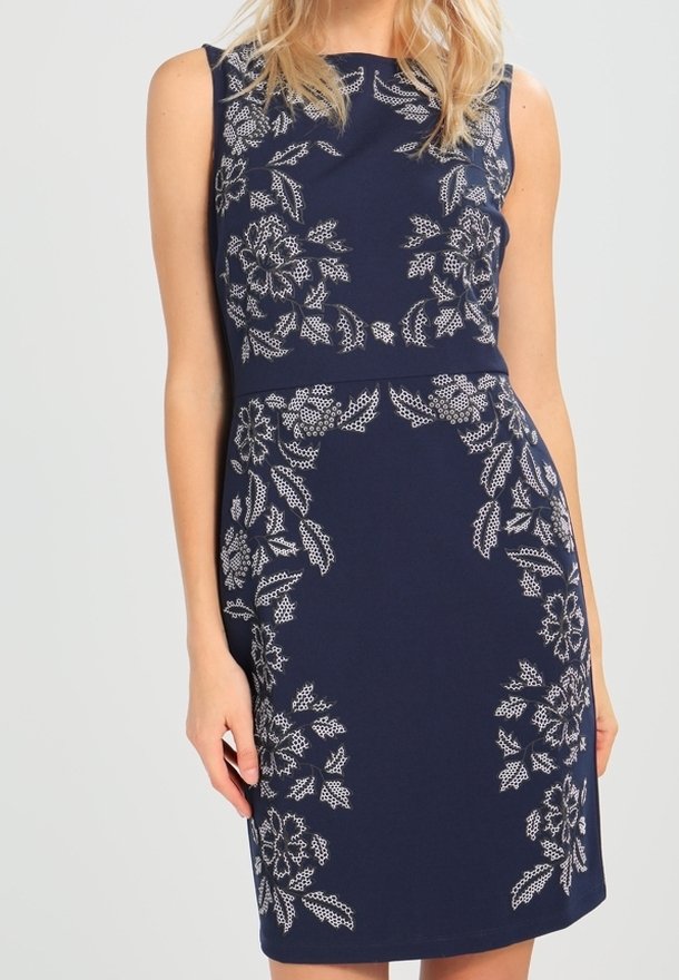 Granatowa sukienka bez rękawów z białym haftem kwiatowym, dopasowany krój, do kolan, gładki materiał i okrągły dekolt.