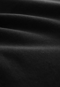 Tela negra de textura suave, con arrugas y pliegues sutiles. La superficie es lisa, sin patrones ni elementos visibles.