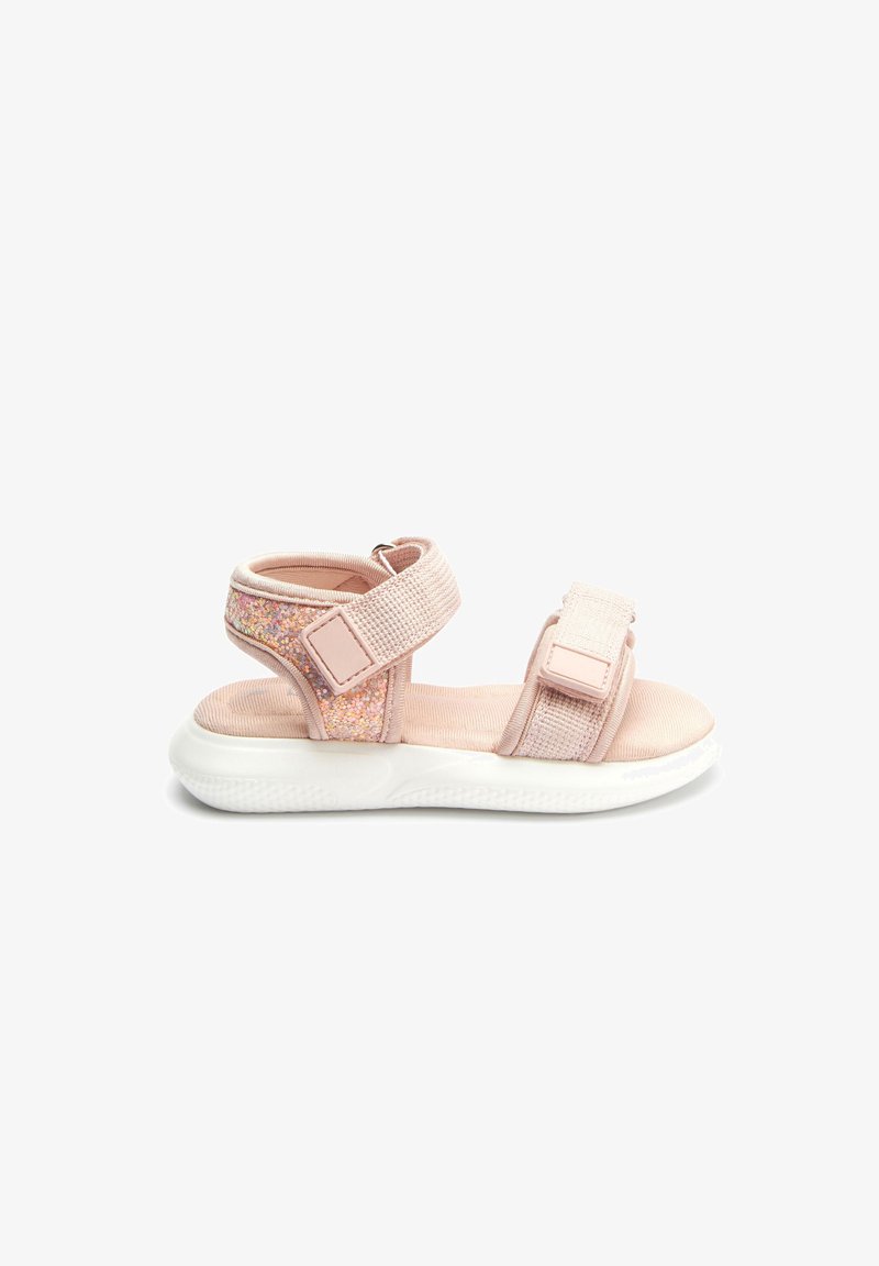 Sandal roz deschis cu două curele reglabil Velcro, un accent strălucitor și o talpă din cauciuc alb. Superior din material texturat pentru confort.