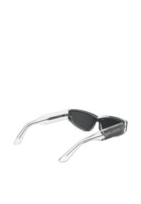 Ochelari de soare cu un cadru transparent, formă sleek de ochi de pisică, lentile întunecate și brațe subțiri, elongate, cu accente argintii.