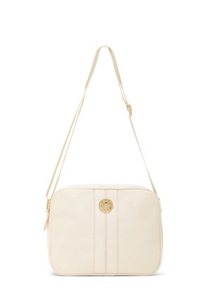 Borsa a tracolla rettangolare color crema con tracolla regolabile e un emblema rotondo dorato al centro davanti.