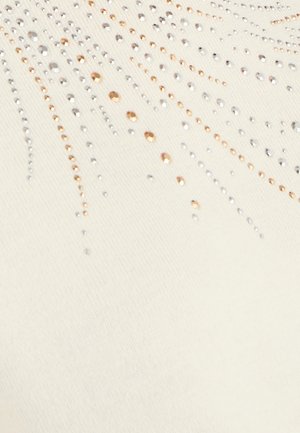 Crèmewit stof met een gestructureerde feel, versierd met zilveren en roségouden pailletten in een zonnestralenpatroon dat vanuit het midden straalt.