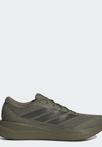 Ραφινάτο αθλητικό παπούτσι Adidas σε ελιά πράσινο με επάνω μέρος από δίχτυ, τρεις μαύρες ρίγες στο πλάι και χοντρή σόλα Cloudfoam.