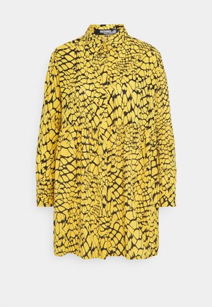 Vestido amarillo de manga larga con un patrón negro agrietado, que cuenta con cuello y cierre de botones, con detalle fruncido en la cintura.