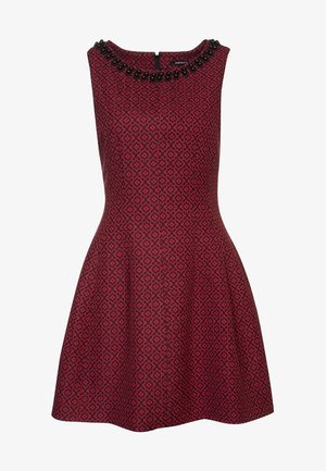 Red patterned dress with a flared skirt, round neckline adorned with black beads, sleeveless design, in a structured fabric.