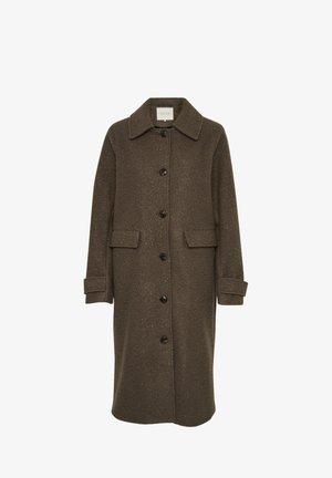 Brūns vilnas mētelis ar apkakles dekoltē, garām piedurknēm un pārāk lielām priekšējām kabatām. Aizdare ar lieliem tumšiem pogiem.