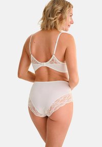 Witte bh met kant en hoge taille slip. Glad materiaal met kantaccenten, verstelbare bandjes en een haaksluiting op de rug.
